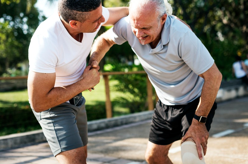 man assisting old man in pain